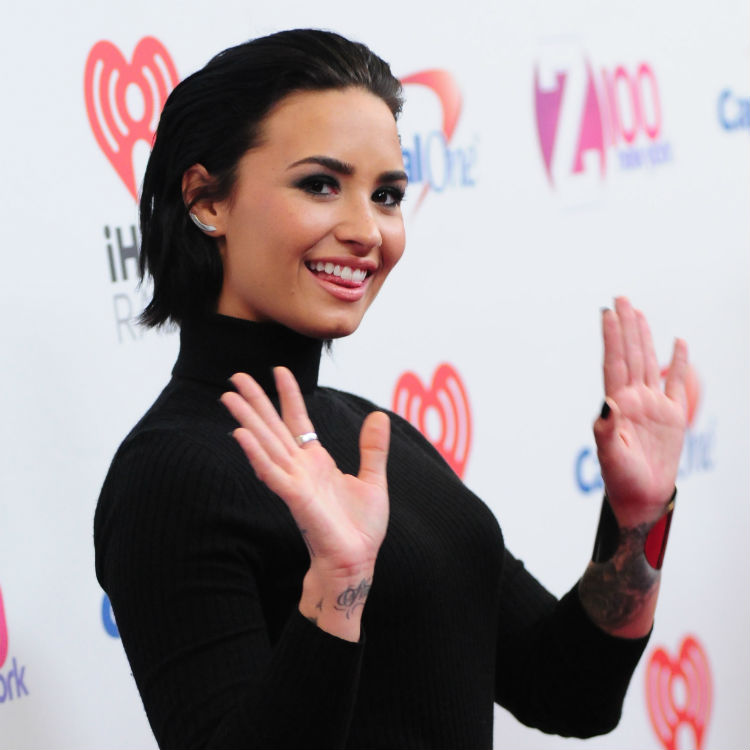 Demi Lovato falls over mic stand live on stage iHeartRadio Jingle Ball