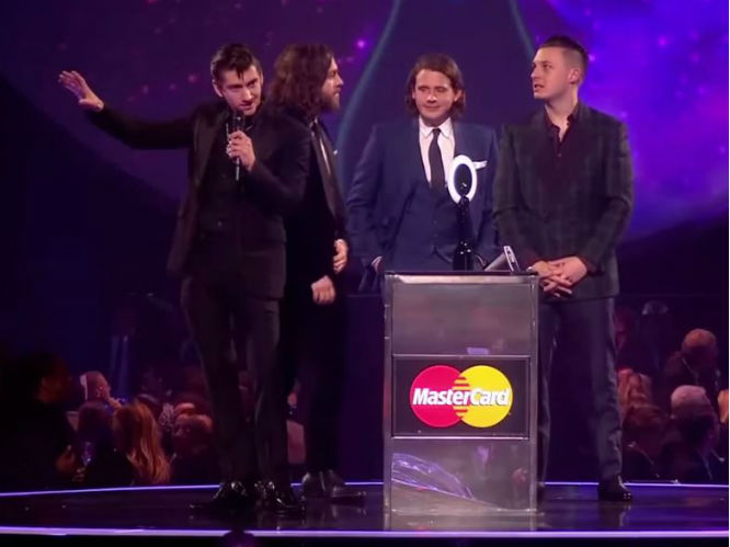 For - The BRIT Awards Speech WAS COOL: Perhaps the band's most divisive moment in recent months, it was a much needed shake up for the ceremony, which had (in previous years) been dominated by the likes of Mumford and Sons, Ben Howard and Ed Sheeran. Turner stood up for guitar music and rock n' roll during his speech and through the lengths of obtuse metaphors summed up the scene very well. Also many argue that he was joking, which fits in with the history of toungue in cheek Alex Turner speeches. Pretty cool if you think about it.